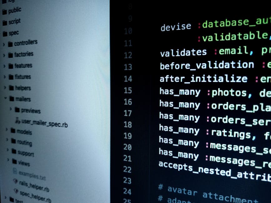 The image displays a close-up of a computer monitor with a dark background showing lines of multicolored programming code, including syntax with keywords, functions, and variables. The code is arrange